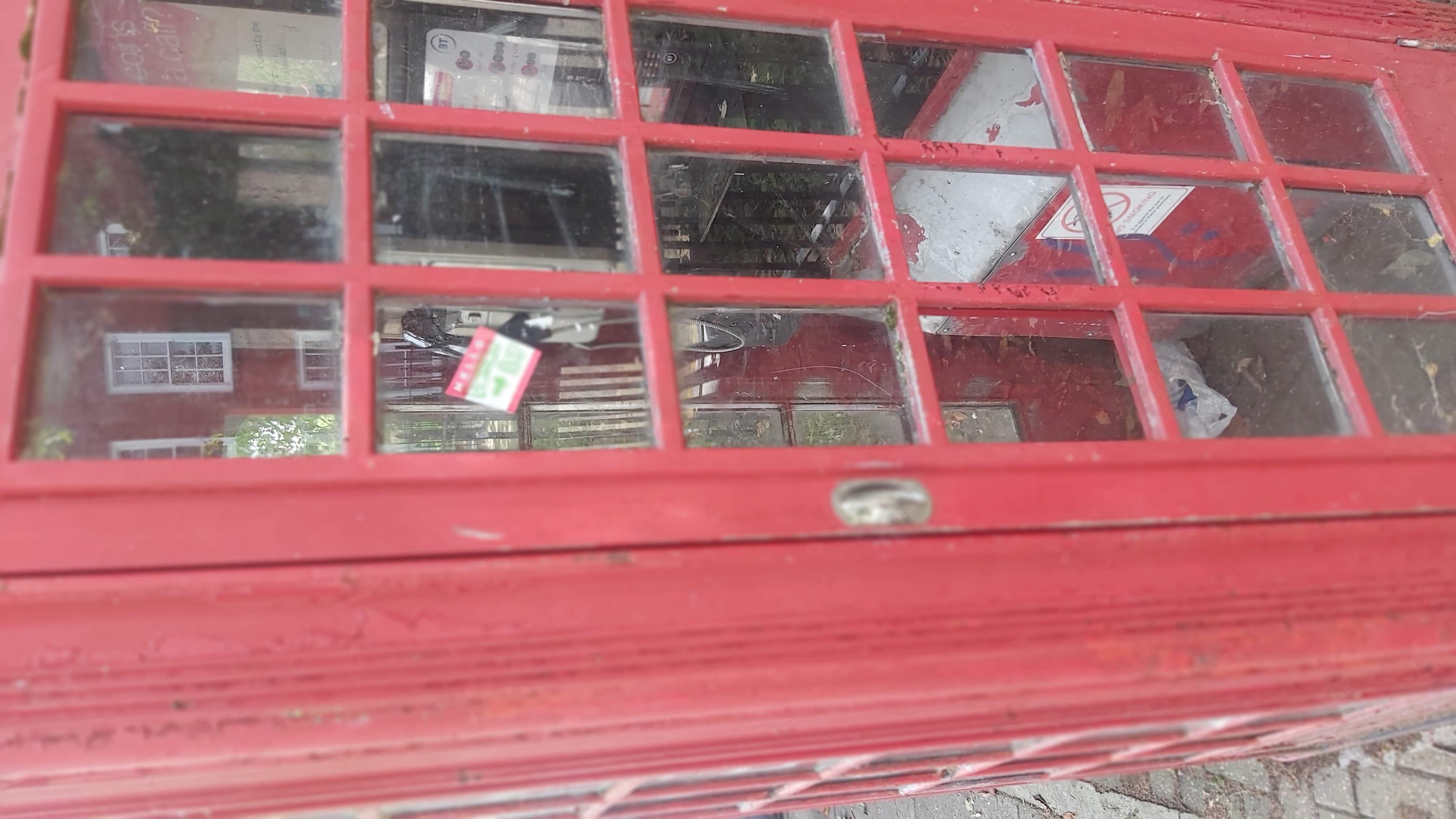 A close-up potrait photo of a red telephone box.